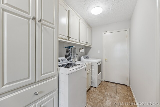 1209 Sherwood Ln, Broken Arrow, OK 74011 - laundry area featuring washing machine and clothes dryer, cabinet space, a textured ceiling, baseboards, and light stone finish flooring