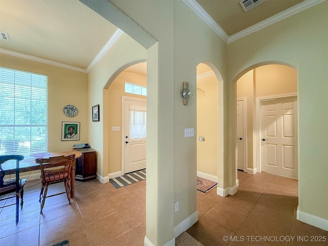1318 Emily Ln, Ada, OK 74820 - foyer featuring arched walkways, ornamental molding, light tile patterned floors, and baseboards