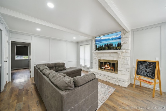 11033 E 66th St, Tulsa, OK 74133 - living area featuring a decorative wall, a stone fireplace, healthy amount of natural light, wood finished floors, and beamed ceiling