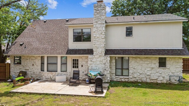 11033 E 66th St, Tulsa, OK 74133 - back of house with stone siding, roof with shingles, a patio, and a chimney