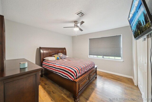 11033 E 66th St, Tulsa, OK 74133 - bedroom featuring wood finished floors, baseboards, a ceiling fan, and a textured ceiling