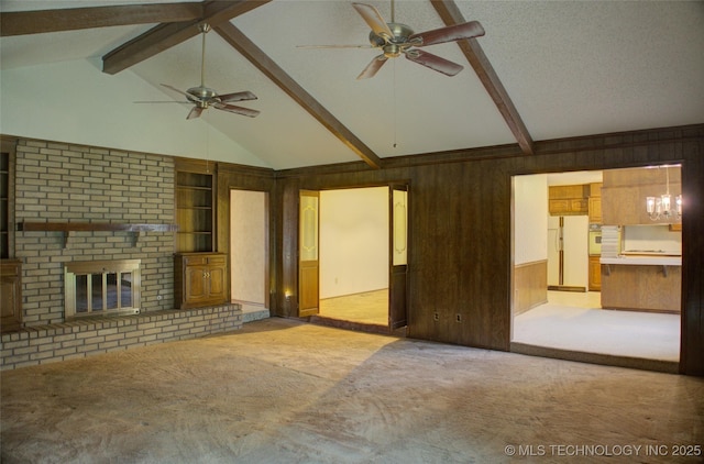 4004 S Hickory Ave, Broken Arrow, OK 74011 - unfurnished living room featuring ceiling fan, wooden walls, light carpet, a fireplace, and a chandelier