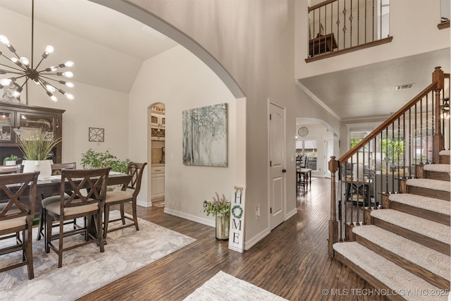 3117 S Hemlock Ct, Broken Arrow, OK 74012 - foyer entrance with arched walkways, dark wood-style floors, stairway, a chandelier, and high vaulted ceiling