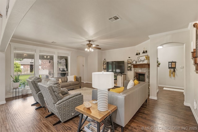 3117 S Hemlock Ct, Broken Arrow, OK 74012 - living area with arched walkways, ceiling fan, baseboards, dark wood-type flooring, and a glass covered fireplace