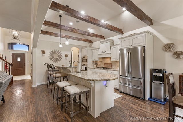 3117 S Hemlock Ct, Broken Arrow, OK 74012 - kitchen with stainless steel appliances, light stone counters, a kitchen bar, beamed ceiling, and arched walkways