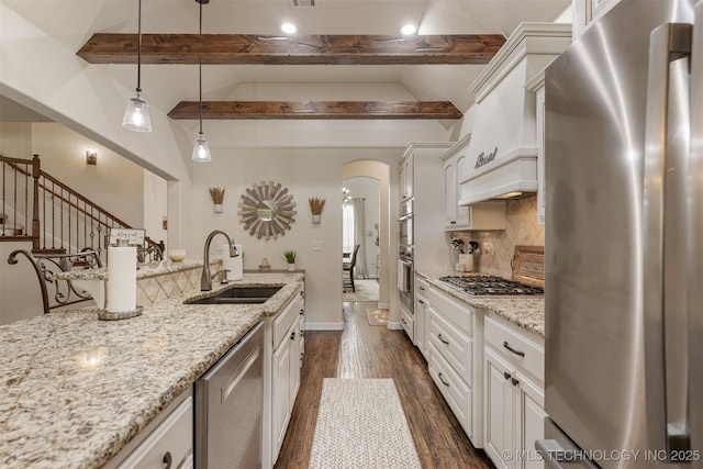 3117 S Hemlock Ct, Broken Arrow, OK 74012 - kitchen with stainless steel appliances, a sink, arched walkways, dark wood finished floors, and decorative backsplash