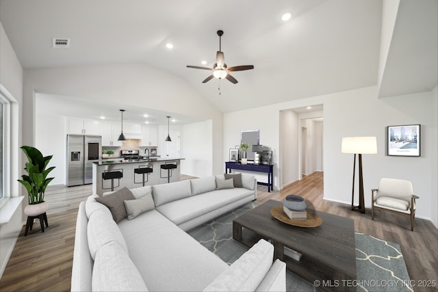12503 N 130th Ave E, Collinsville, OK 74021 - living room featuring wood finished floors, a ceiling fan, vaulted ceiling, and recessed lighting
