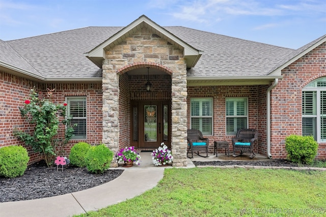 23532 N 5 Mile Rd, Fort Gibson, OK 74434 - doorway to property with a shingled roof, brick siding, stone siding, and a lawn