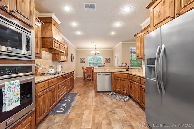 23532 N 5 Mile Rd, Fort Gibson, OK 74434 - kitchen featuring stainless steel appliances, ornamental molding, a sink, a peninsula, and a chandelier