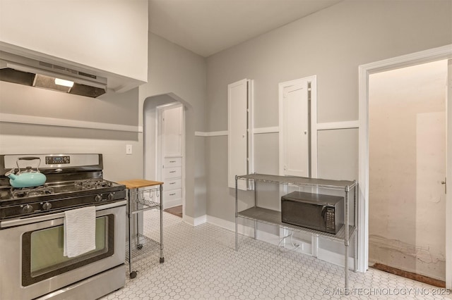 2305 E 13th St, Tulsa, OK 74104 - kitchen featuring gas range, arched walkways, baseboards, and exhaust hood