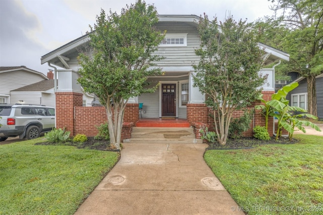 2305 E 13th St, Tulsa, OK 74104 - obstructed view of property featuring brick siding, a front lawn, and covered porch