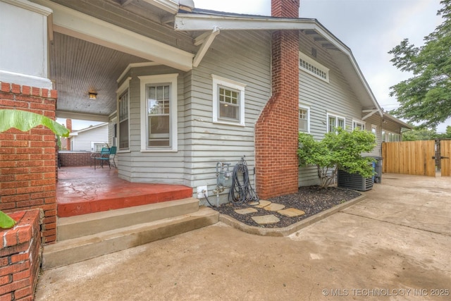 2305 E 13th St, Tulsa, OK 74104 - view of property exterior featuring a chimney, a porch, and cooling unit