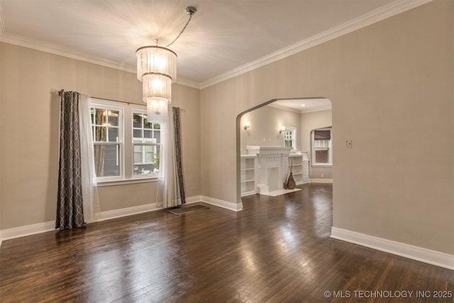 2305 E 13th St, Tulsa, OK 74104 - empty room featuring arched walkways, crown molding, a chandelier, wood finished floors, and baseboards