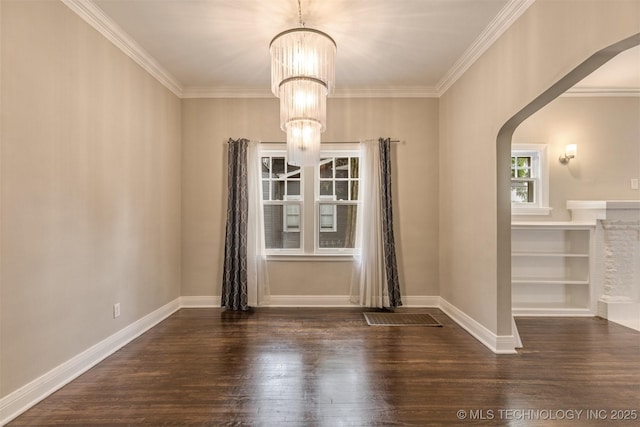 2305 E 13th St, Tulsa, OK 74104 - unfurnished dining area featuring arched walkways, a chandelier, wood finished floors, crown molding, and baseboards