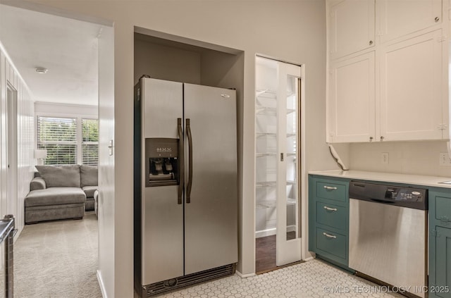 2305 E 13th St, Tulsa, OK 74104 - kitchen with stainless steel appliances, light countertops, white cabinetry, green cabinets, and decorative backsplash