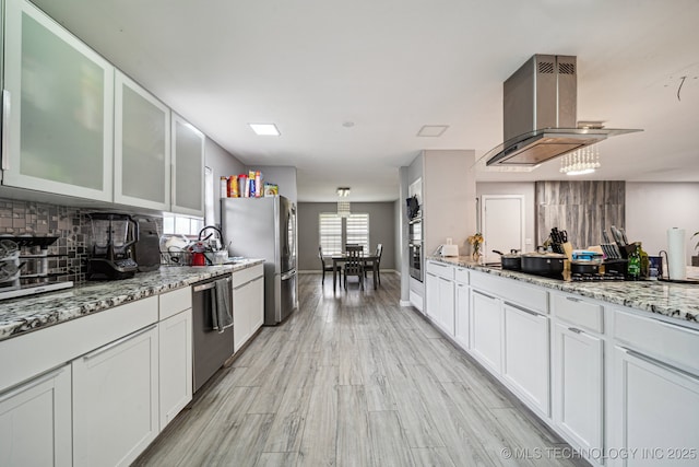 6407 S 110th E Ave, Tulsa, OK 74133 - kitchen featuring stainless steel appliances, island range hood, backsplash, and white cabinetry
