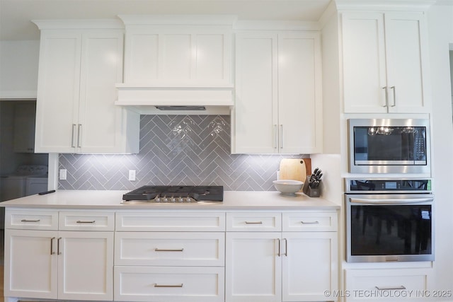 13657 S 21st Ct E, Bixby, OK 74008 - kitchen with appliances with stainless steel finishes, washing machine and clothes dryer, light countertops, and white cabinetry