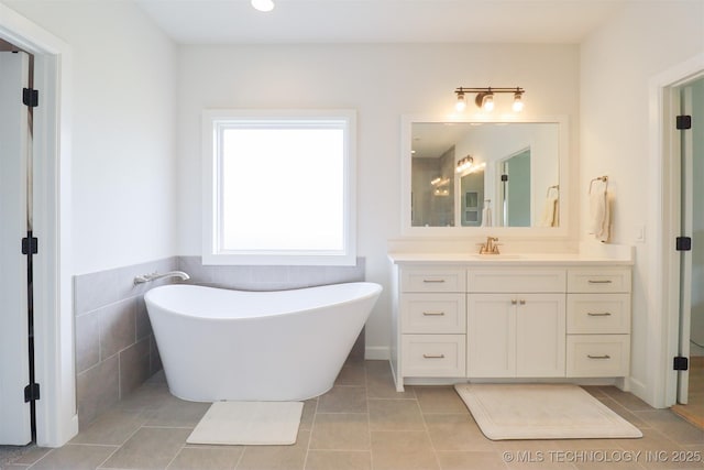 13657 S 21st Ct E, Bixby, OK 74008 - full bathroom featuring vanity, a freestanding bath, tile patterned floors, and tile walls