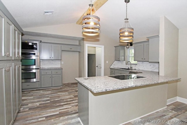 2005 Holly Rd, Claremore, OK 74017 - kitchen featuring gray cabinetry, vaulted ceiling, a sink, black electric stovetop, and wood finished floors
