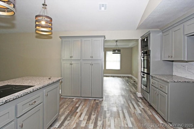 2005 Holly Rd, Claremore, OK 74017 - kitchen featuring gray cabinetry, stainless steel double oven, light wood finished floors, hanging light fixtures, and vaulted ceiling