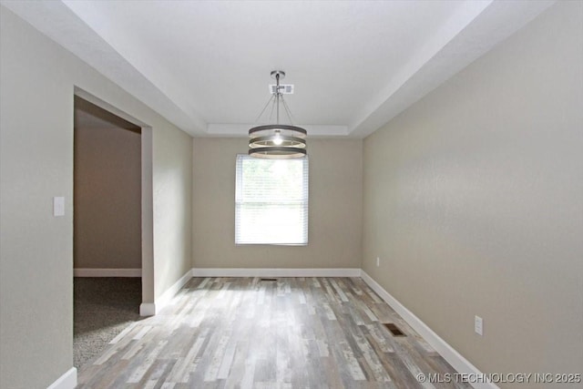 2005 Holly Rd, Claremore, OK 74017 - unfurnished dining area with light wood-style flooring, baseboards, a chandelier, and a raised ceiling