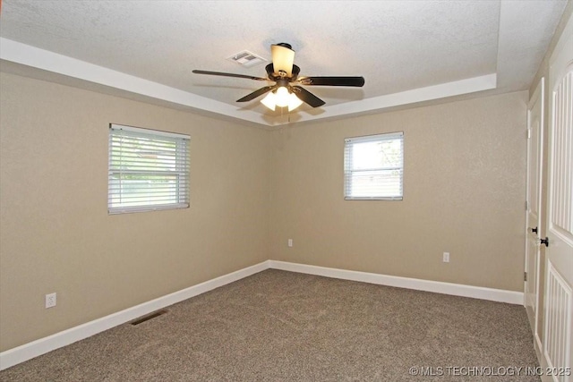 2005 Holly Rd, Claremore, OK 74017 - empty room with a raised ceiling, carpet flooring, a ceiling fan, baseboards, and a textured ceiling