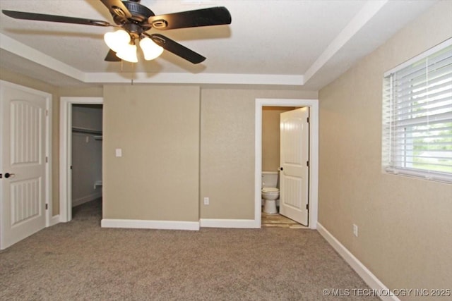 2005 Holly Rd, Claremore, OK 74017 - unfurnished bedroom featuring a tray ceiling, carpet flooring, and a ceiling fan