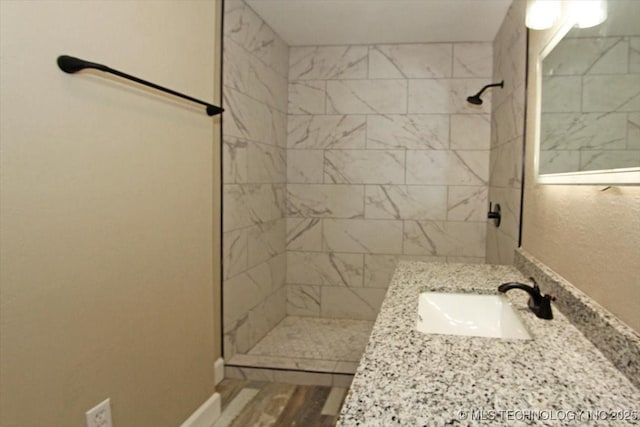 2005 Holly Rd, Claremore, OK 74017 - full bathroom featuring tiled shower, vanity, and wood finished floors