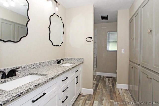2005 Holly Rd, Claremore, OK 74017 - full bath featuring wood finished floors, a shower, double vanity, and baseboards