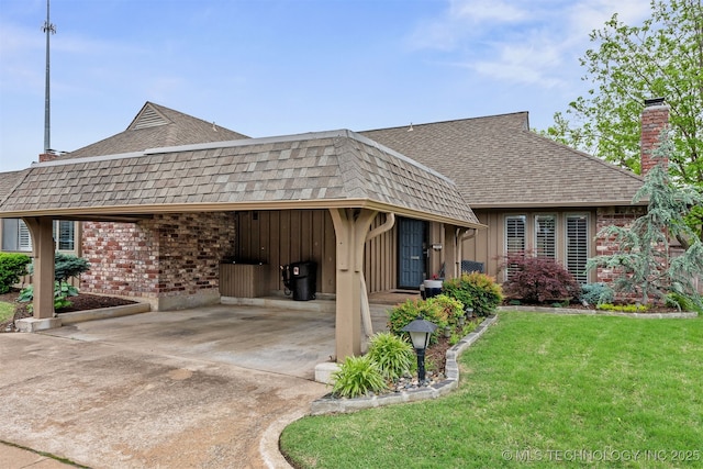 5206 S Harvard Ave Unit 308, Tulsa, OK 74135 - view of front of property featuring a chimney, a shingled roof, driveway, a front yard, and an attached carport