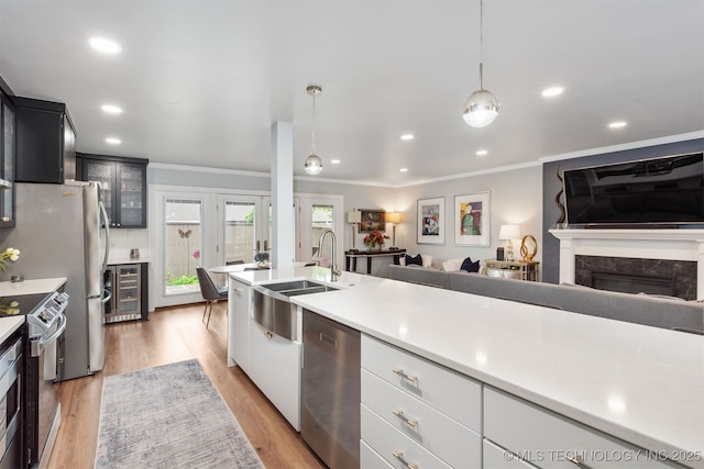 5206 S Harvard Ave Unit 308, Tulsa, OK 74135 - kitchen featuring appliances with stainless steel finishes, a sink, wine cooler, crown molding, and light countertops