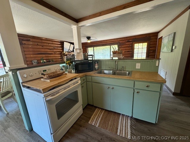 13248 Spelling Rd, Davis, OK 73030 - kitchen featuring electric stove, black microwave, a sink, rustic walls, and dark wood-style floors
