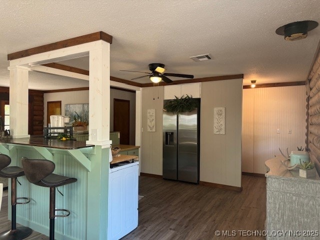 13248 Spelling Rd, Davis, OK 73030 - kitchen featuring stainless steel refrigerator with ice dispenser, dark wood-type flooring, a textured ceiling, ceiling fan, and a kitchen breakfast bar