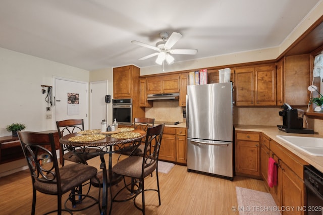 3823 S 88th E Pl, Tulsa, OK 74145 - kitchen with black appliances, brown cabinets, light countertops, ceiling fan, and tasteful backsplash