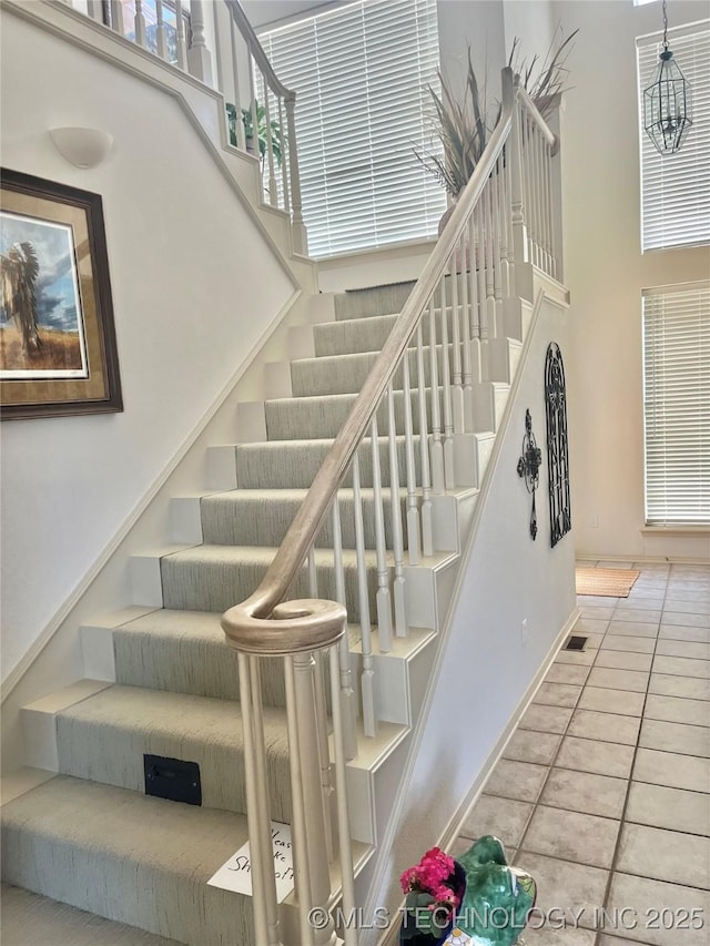 5168 Tower Dr, Kingston, OK 73439 - stairs with a towering ceiling, tile patterned flooring, and baseboards