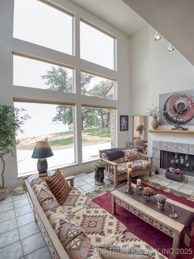 5168 Tower Dr, Kingston, OK 73439 - living room featuring a high ceiling, a tiled fireplace, and tile patterned flooring