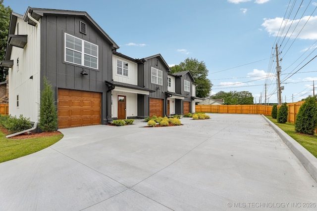1448 N Main St Unit 2, Tulsa, OK 74106 - view of front facade with a garage, concrete driveway, and board and batten siding