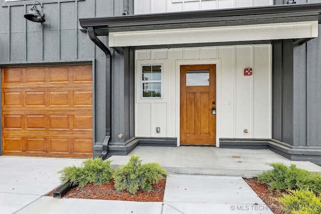 1448 N Main St Unit 2, Tulsa, OK 74106 - property entrance with board and batten siding, a garage, and covered porch