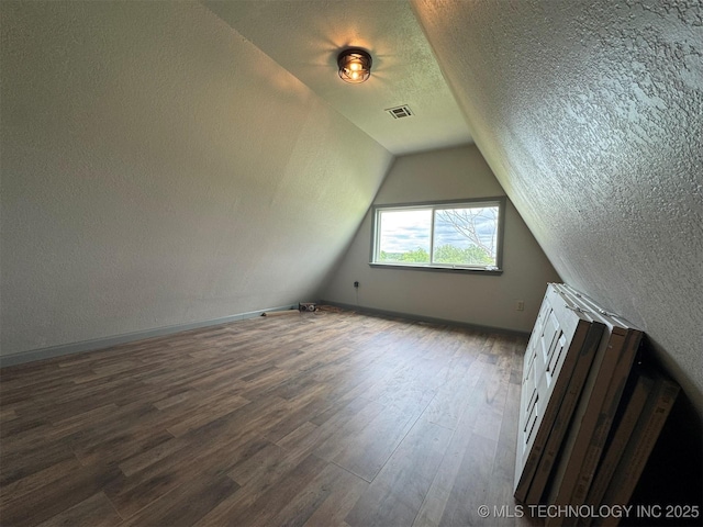 7235 Sunshine Rd, Davis, OK 73030 - additional living space featuring dark wood finished floors, a textured ceiling, lofted ceiling, and baseboards