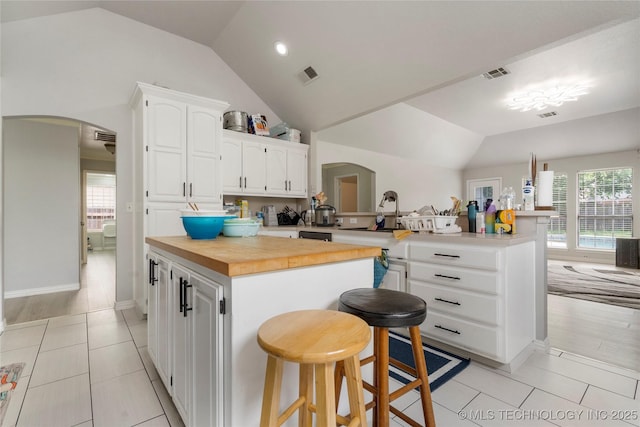 1105 N Joshua Ave, Broken Arrow, OK 74012 - kitchen with arched walkways, a peninsula, vaulted ceiling, a sink, and wood counters