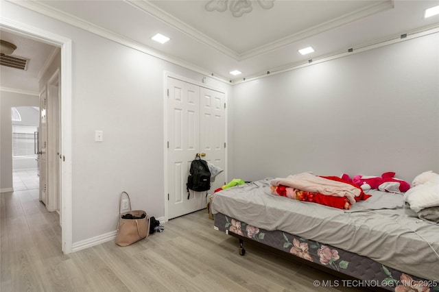 1105 N Joshua Ave, Broken Arrow, OK 74012 - bedroom with crown molding, light wood-type flooring, a tray ceiling, baseboards, and a closet