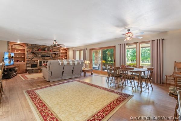1485 Old Ketchum Rd, Langley, OK 74350 - living area featuring ceiling fan, wood finished floors, built in shelves, and a fireplace
