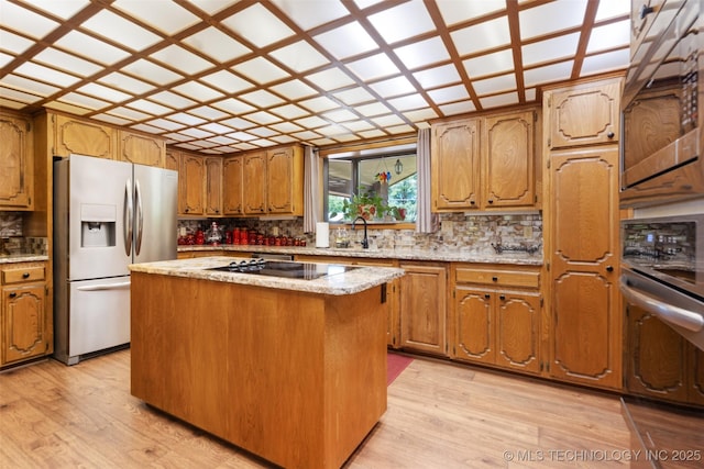 1485 Old Ketchum Rd, Langley, OK 74350 - kitchen with appliances with stainless steel finishes, tasteful backsplash, light wood finished floors, a kitchen island, and a sink