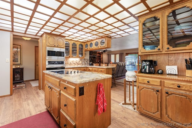 1485 Old Ketchum Rd, Langley, OK 74350 - kitchen featuring appliances with stainless steel finishes, a center island, light wood-style floors, backsplash, and glass insert cabinets