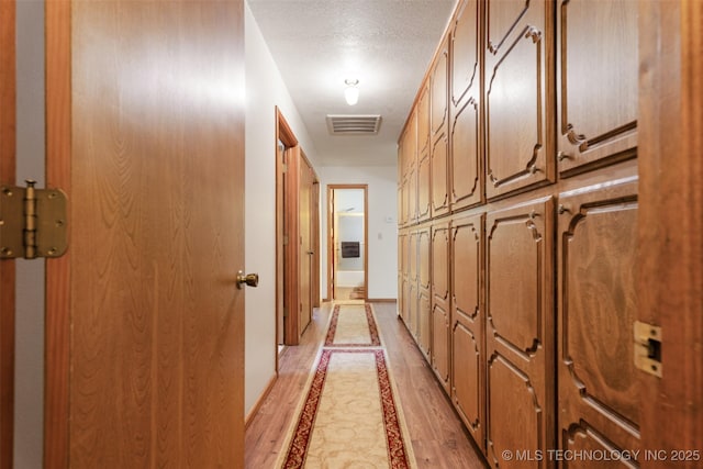 1485 Old Ketchum Rd, Langley, OK 74350 - corridor with inlaid floor details, a textured ceiling, baseboards, and light wood-type flooring