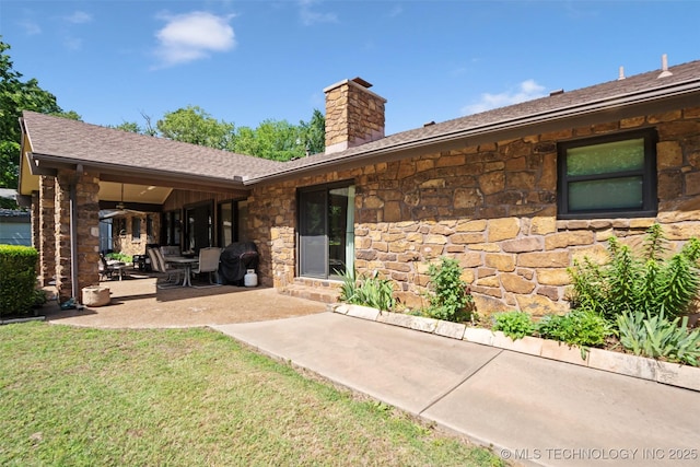 1485 Old Ketchum Rd, Langley, OK 74350 - rear view of house featuring stone siding, a chimney, a patio area, a yard, and roof with shingles
