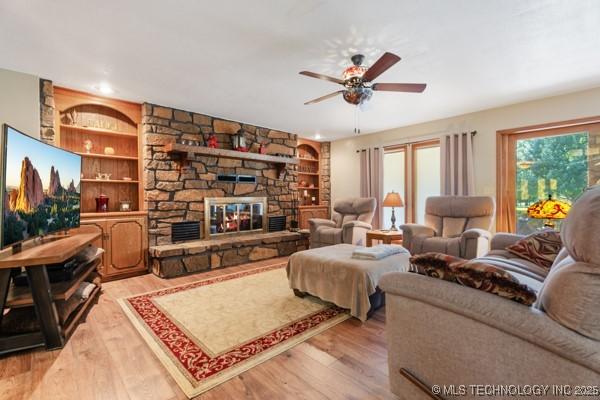 1485 Old Ketchum Rd, Langley, OK 74350 - living room with light wood-style floors, ceiling fan, built in shelves, and a stone fireplace