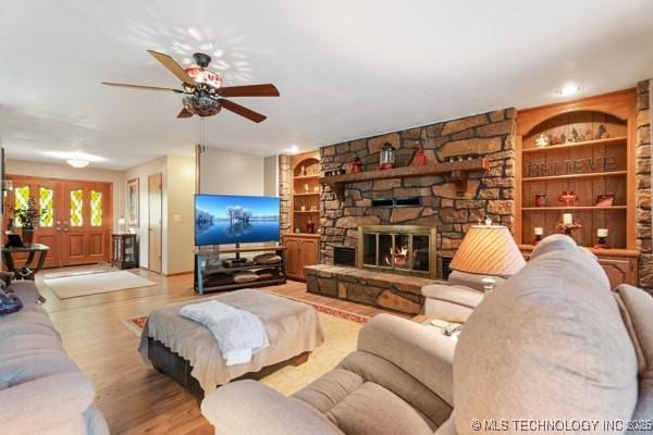 1485 Old Ketchum Rd, Langley, OK 74350 - living room with built in features, ceiling fan, wood finished floors, and a fireplace