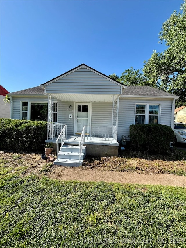 4607 E 4th Pl, Tulsa, OK 74112 - view of front facade with covered porch, roof with shingles, and a front yard