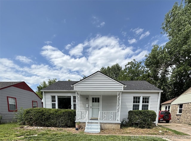 4607 E 4th Pl, Tulsa, OK 74112 - bungalow with covered porch and roof with shingles